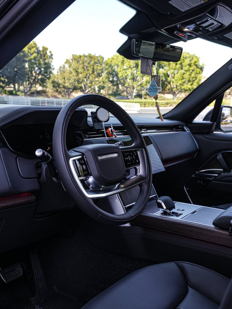 Range Rover cabin showing the steering wheel, dashboard, center console and windshield.