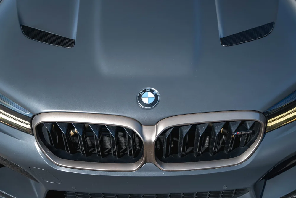 BMW M5 CS hood vents, roundel and bronze-colored grille surround in a close elevated front view