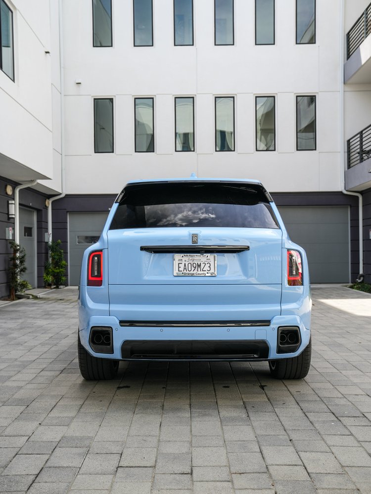 Powder Blue Cullinan Series II Black Badge viewed from the rear with vertical taillights and a dark lower bumper