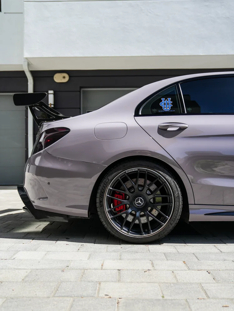 Rear wheel, fuel door, light-grey quarter panel and part of the tall wing on the C 63 S