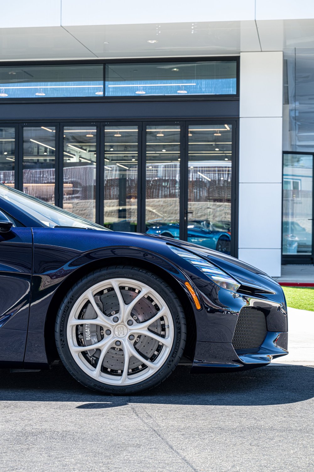 Side view of the W16 Mistral front wheel, blue fender and low front lip above the pavement