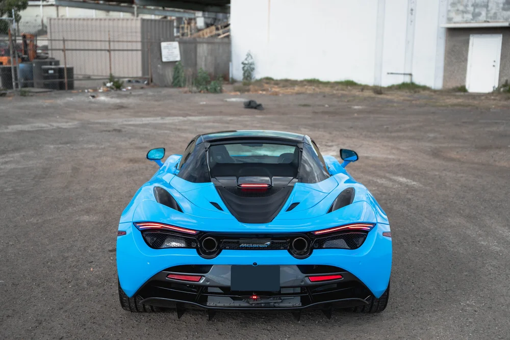 Blue McLaren 720S rear and engine-cover layout photographed from an elevated angle