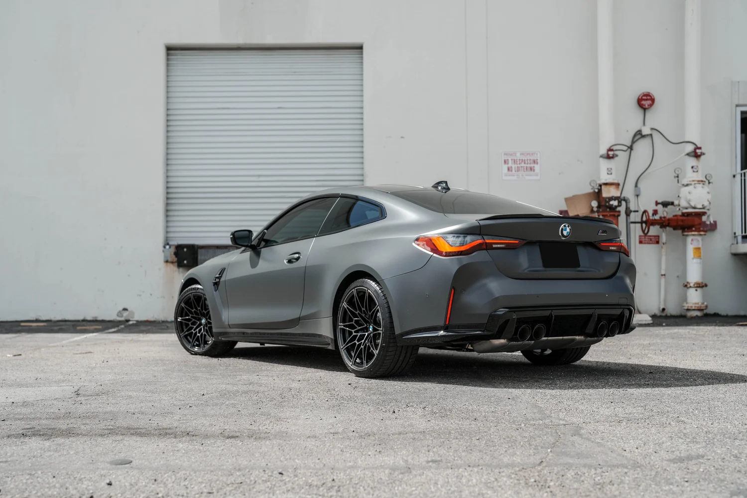 Black BMW M4 after Matte PPF, Window Tint and Ceramic Coating, rear-left three-quarter view