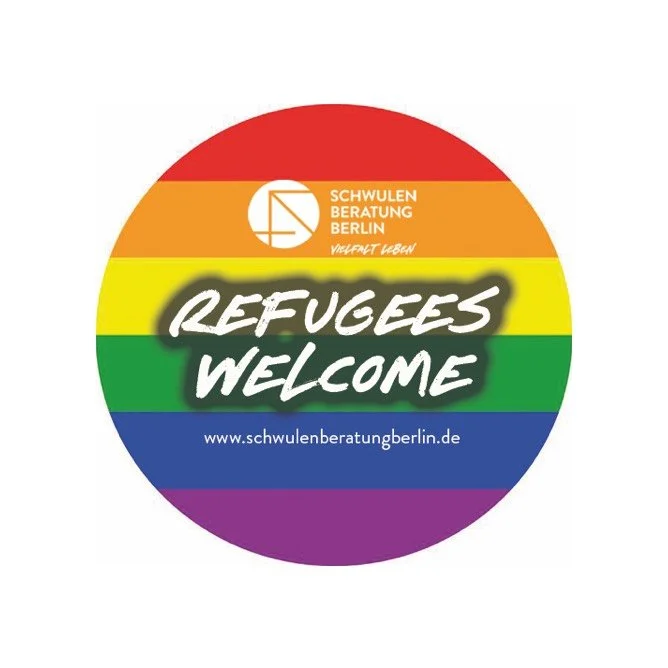 Round badge with rainbow stripes, displaying the words 'REFUGEES WELCOME' in bold white text, a logo and the text 'Schwulenberatung Berlin,' and the website www.schwulenberatungberlin.de.