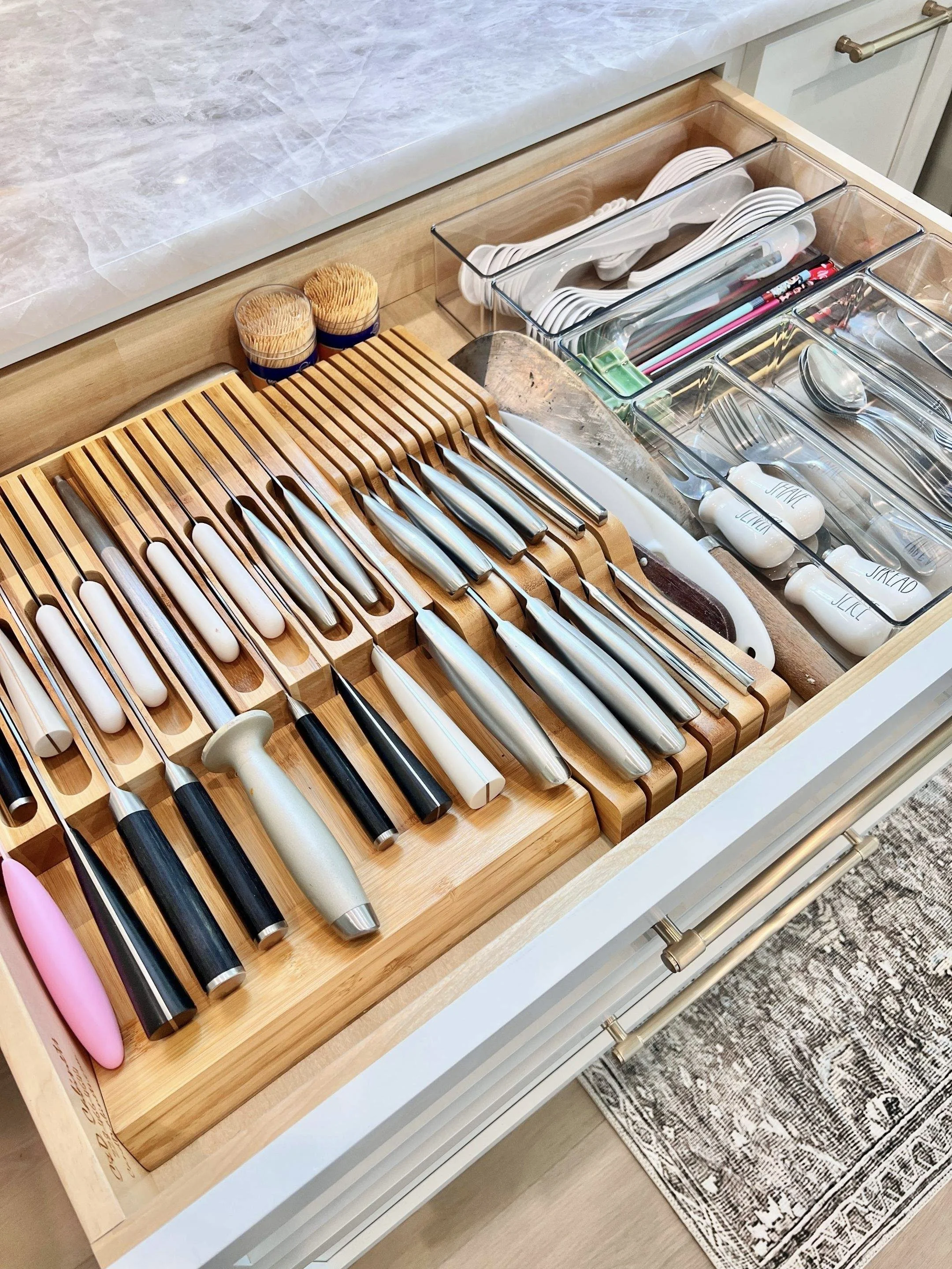 Kitchen drawer organized with knives, cooking utensils, chopsticks, and storage containers.