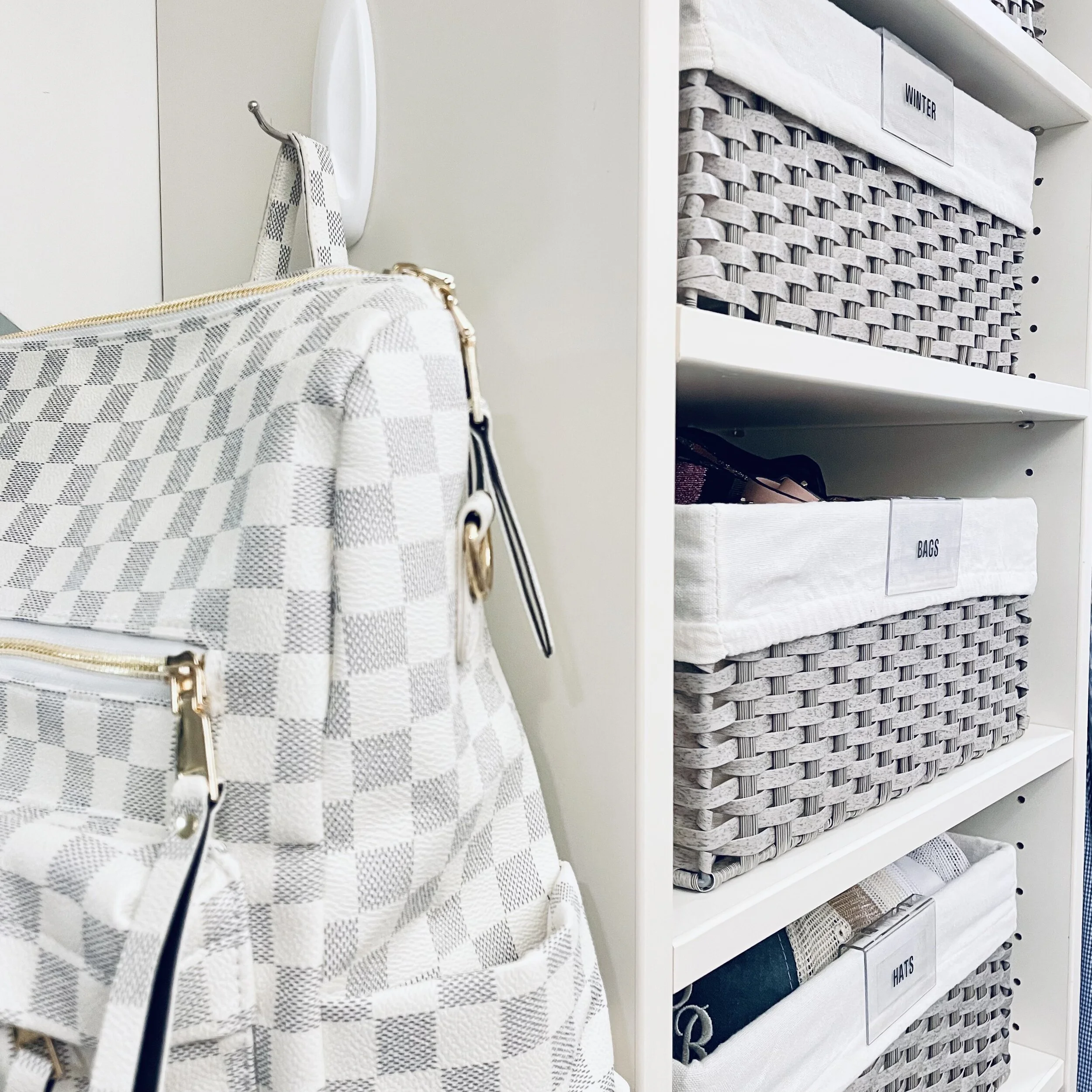 Gray labeled baskets and a Command hook holding a bag, neatly organized by Sorted Professional Organizing in New Orleans.