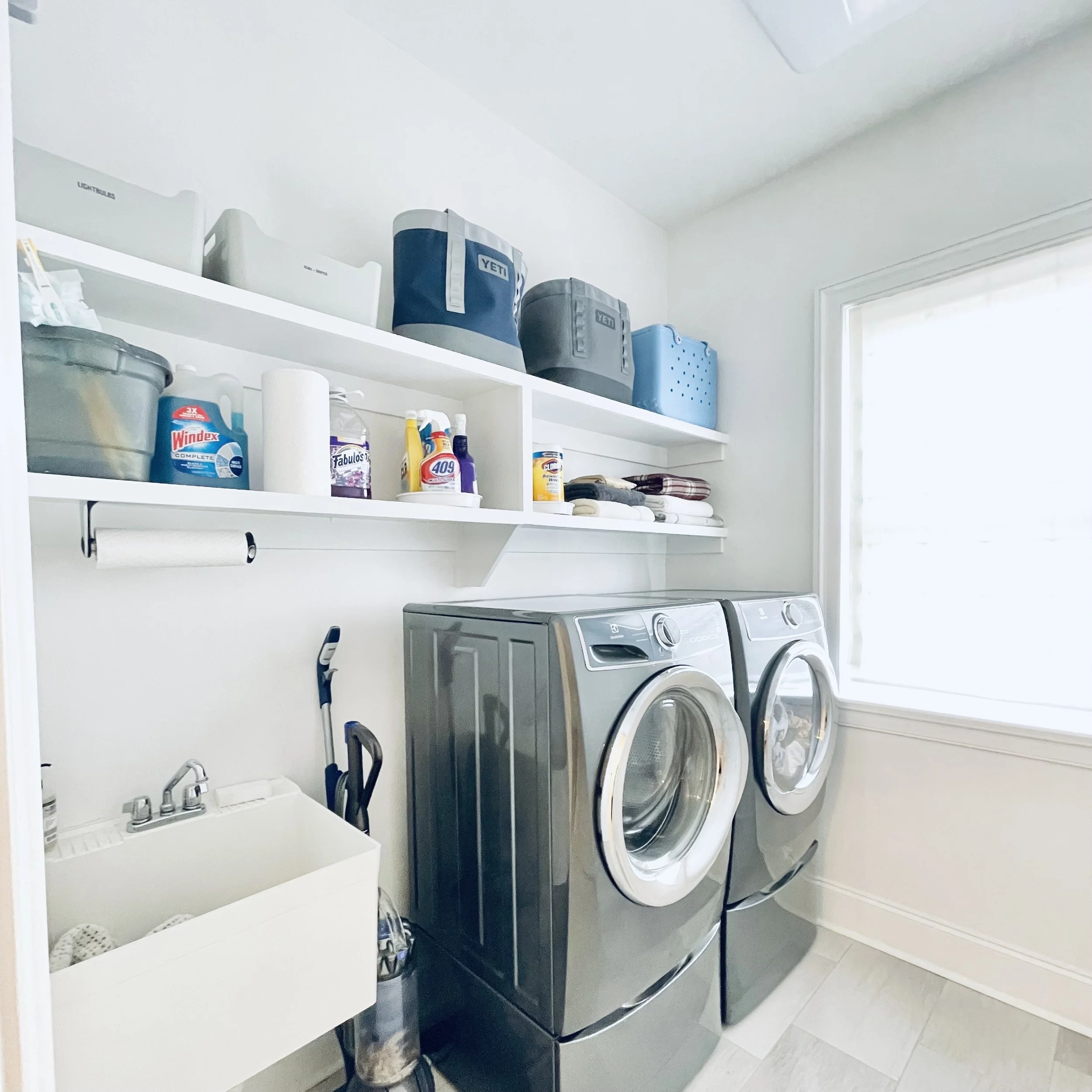 Clean and well organized laundry room with utility sink decluttered by Sorted Professional Organizing in New Orleans.