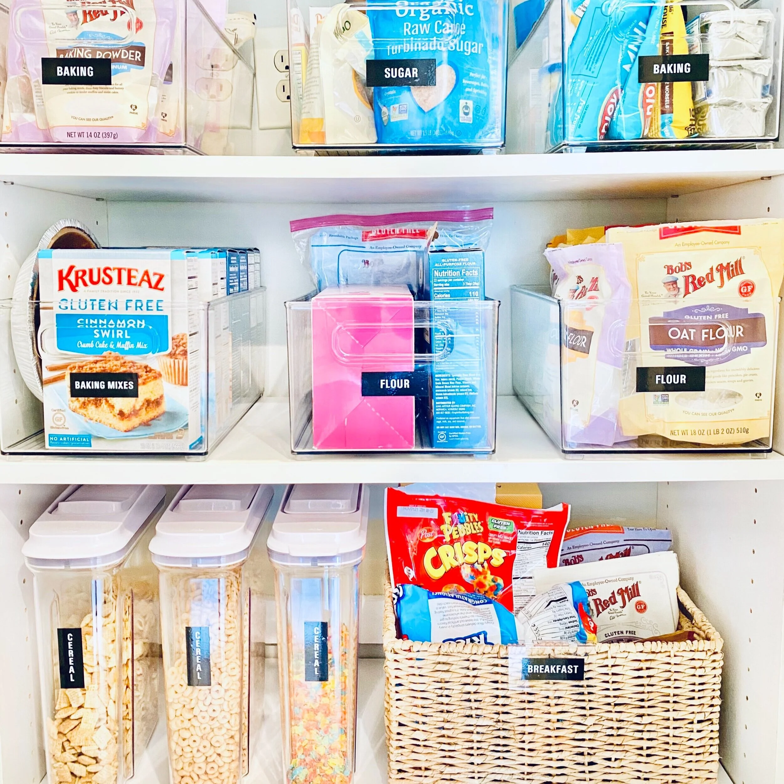 Reach-in pantry shelves with labeled The Home Edit acrylic bins and basket decluttered by Sorted Professional Organizing in New Orleans.