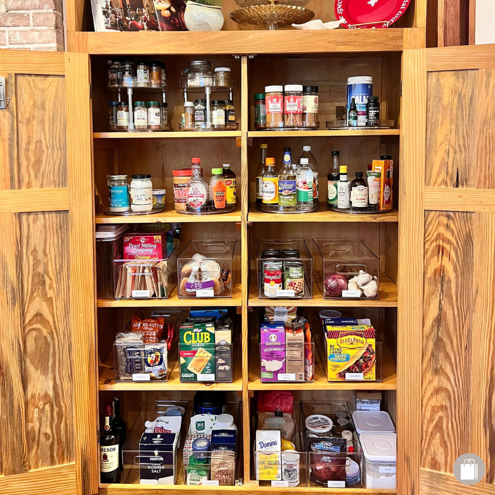 Open wooden cabinet with spices, canned foods, and pantry items on shelves, above a lower section of the cabinet.