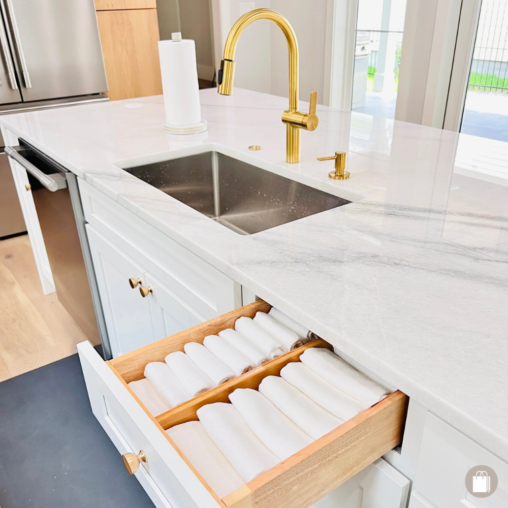 Organized white New Orleans kitchen with neatly folded dish towels by the sink, showcasing Sorted Professional Organizing's efficient systems.