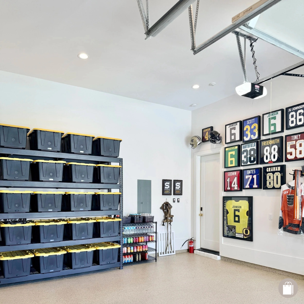 A sports memorabilia room with framed jerseys and helmets on the wall, black storage bins on metal shelves, and shelves with spray paint and sports equipment.