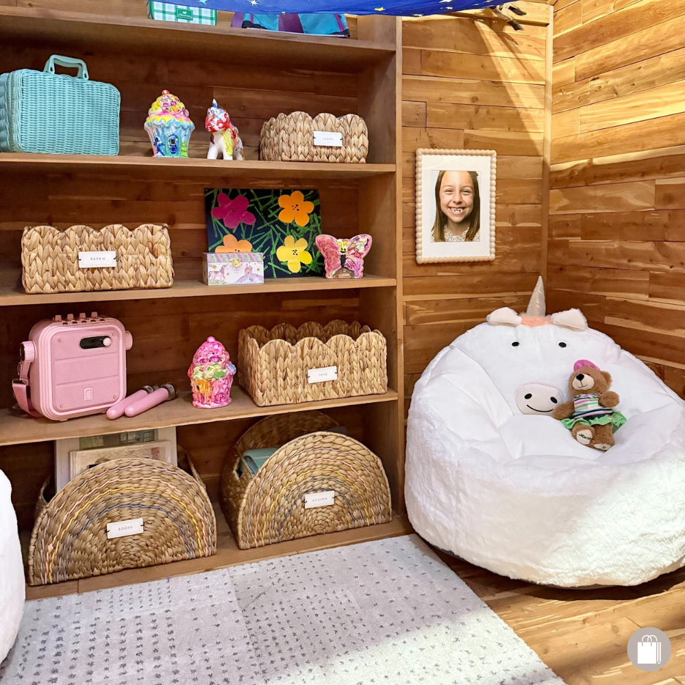 Girls' playroom with unicorn bean bag, scalloped baskets, karaoke machine, and teddy bear
