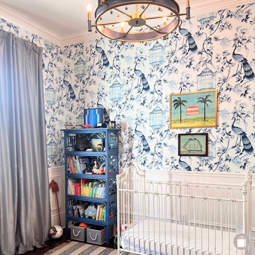 Baby boy nursery featuring a crib and an organized bookcase, styled and organized by Sorted Professional Organizing.