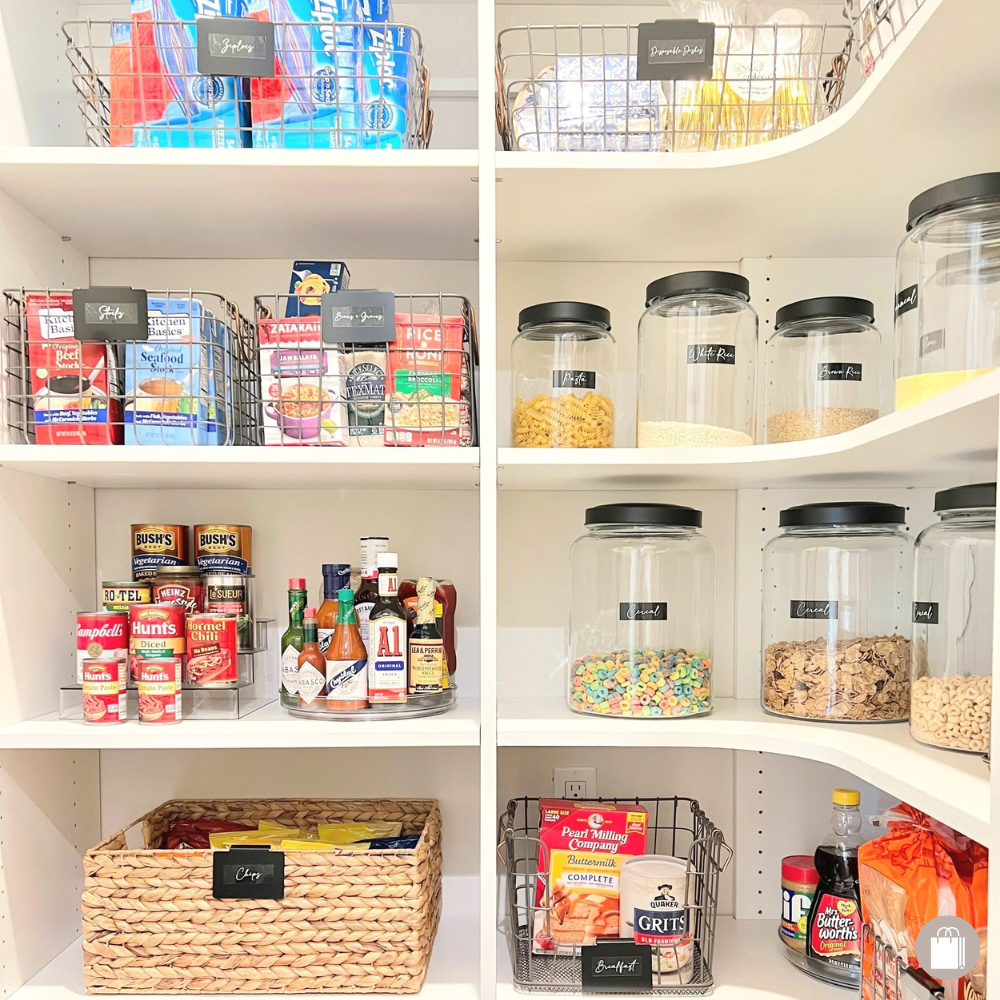 Walk-in pantry with labeled glass containers with black tops, wire baskets, seagrass baskets, can risers, and turntables, all organized by Sorted Professional Organizing in New Orleans.