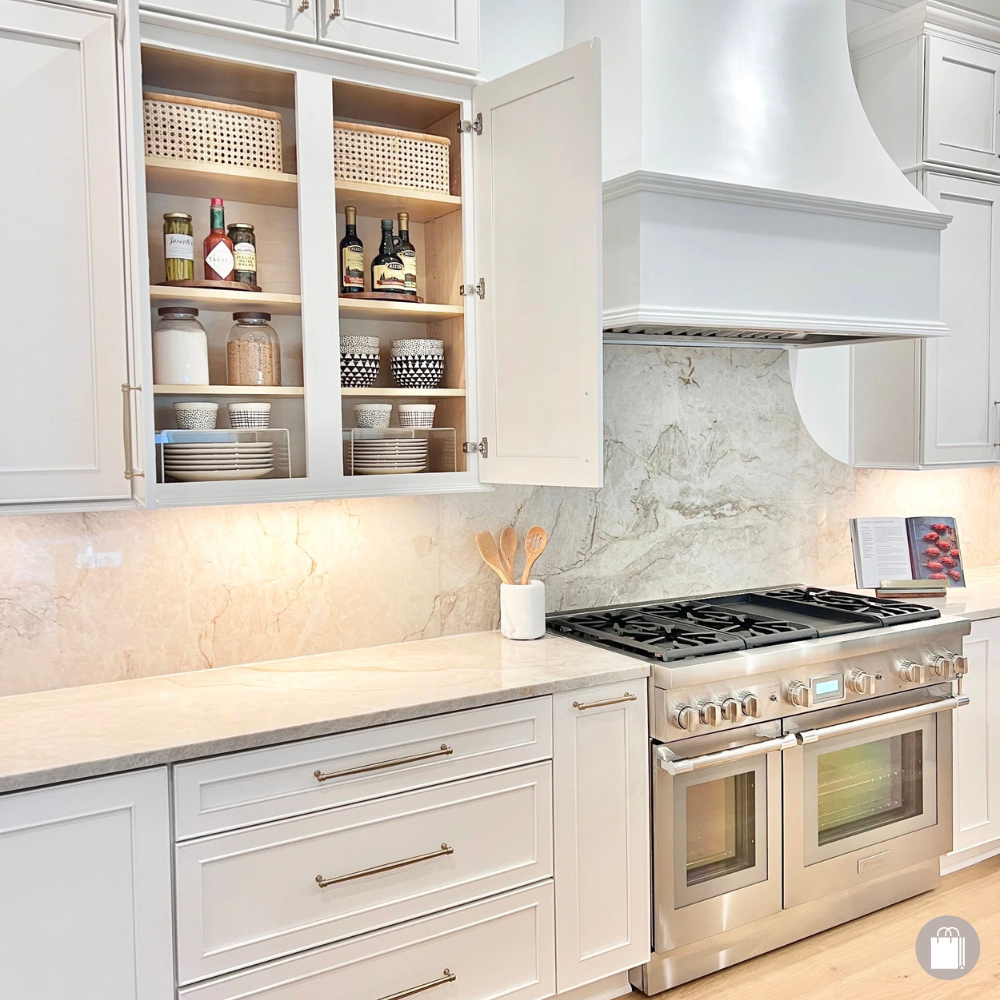 Pristine kitchen cabinet organized with turntables, acrylic risers, and storage baskets by Sorted Professional Organizing in New Orleans.
