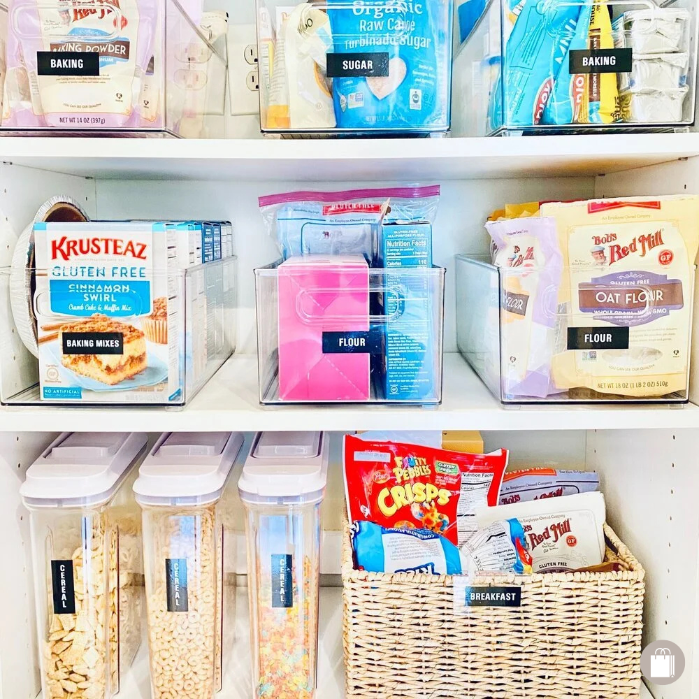 Reach-in pantry shelves with labeled The Home Edit acrylic bins and basket decluttered by Sorted Professional Organizing in New Orleans.