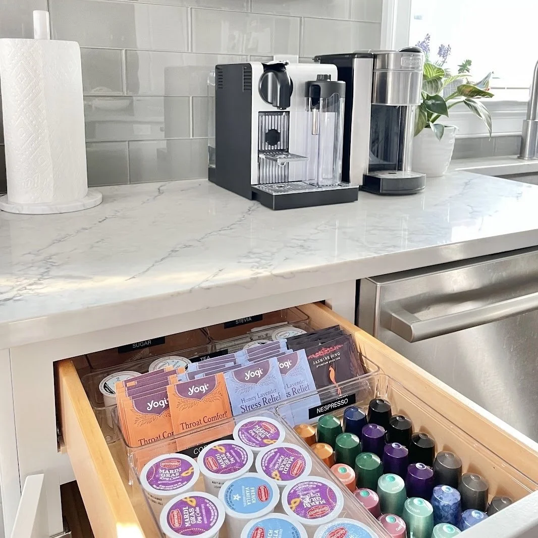Drawer with coffee pods and tea bags neatly organized by Sorted Professional Organizing, with a coffee maker on the counter.