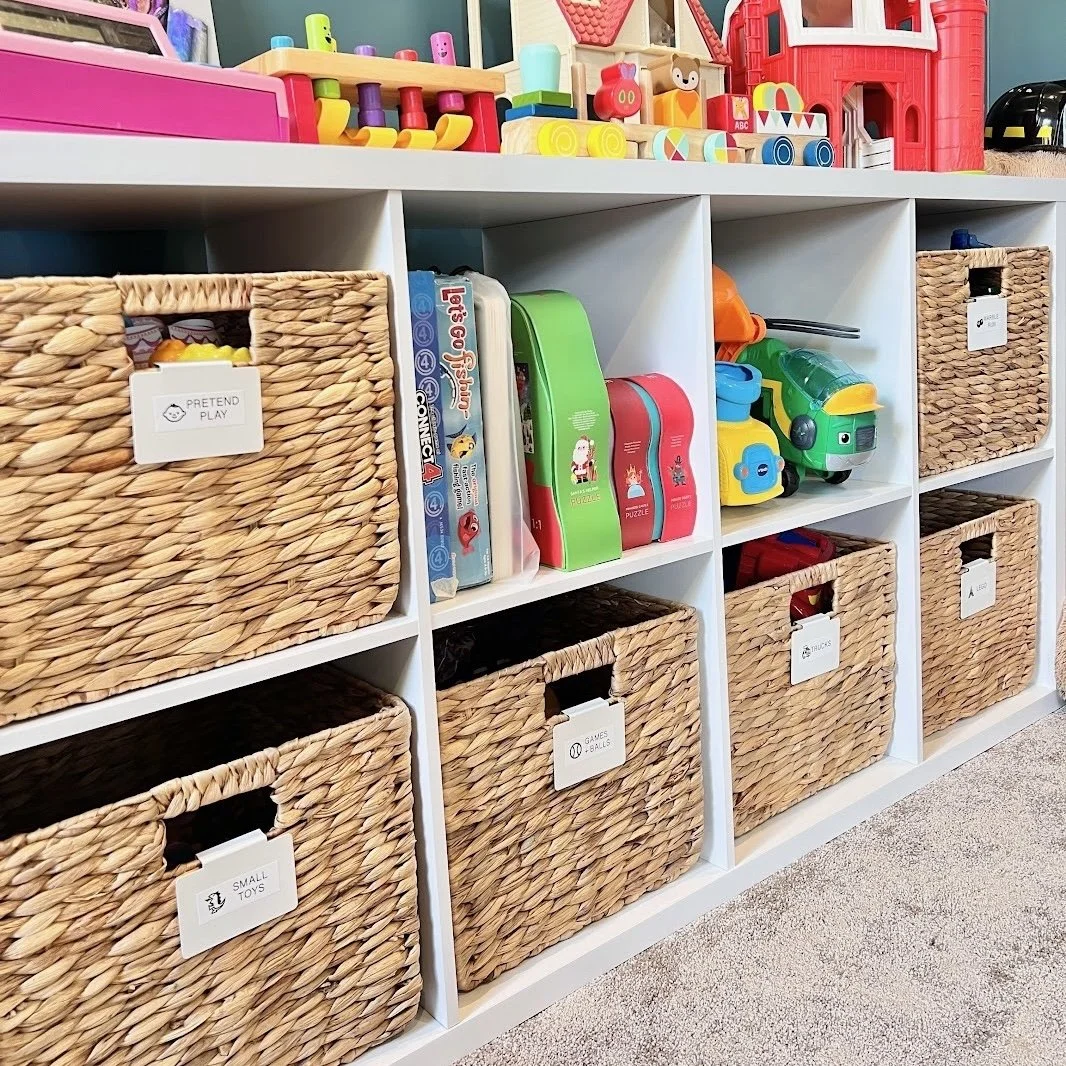 Playroom cubbies with labeled cube seagrass baskets and neatly organized toys, arranged by Sorted Professional Organizing in New Orleans.