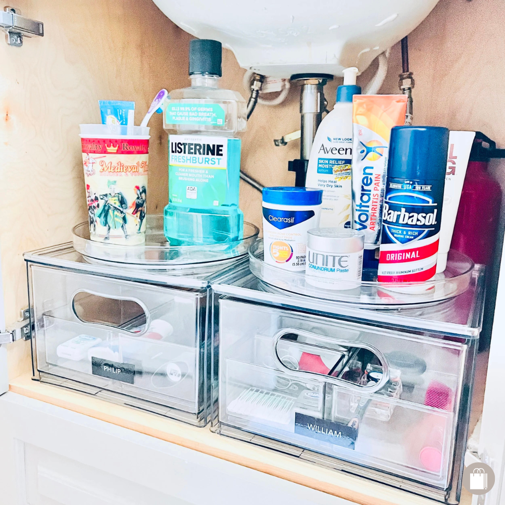 Hygiene products organized under a bathroom sink with acrylic turntables and drawers decluttered by Sorted Professional Organizing in New Orleans.