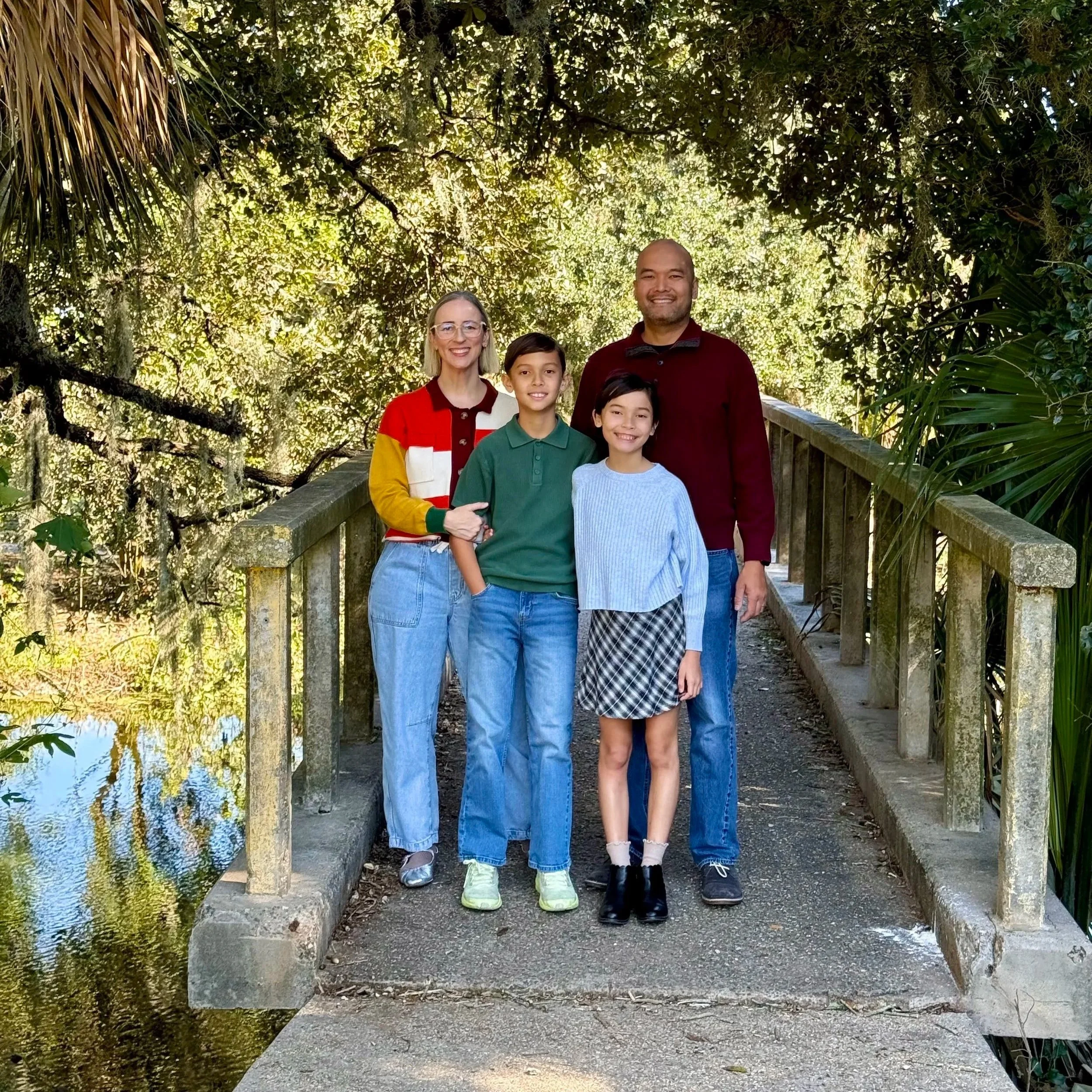 Sorted Professional Organizing Founder Victoria Tran with husband, son, and daughter on a cement bridge in City Park underneath a tree