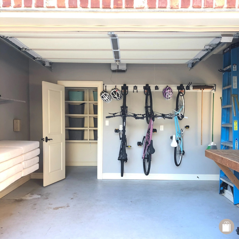 Sorted garage space with wall mounted bike rack, ladder, and closet with organized bins decluttered by Sorted Professional Organizing in New Orleans.