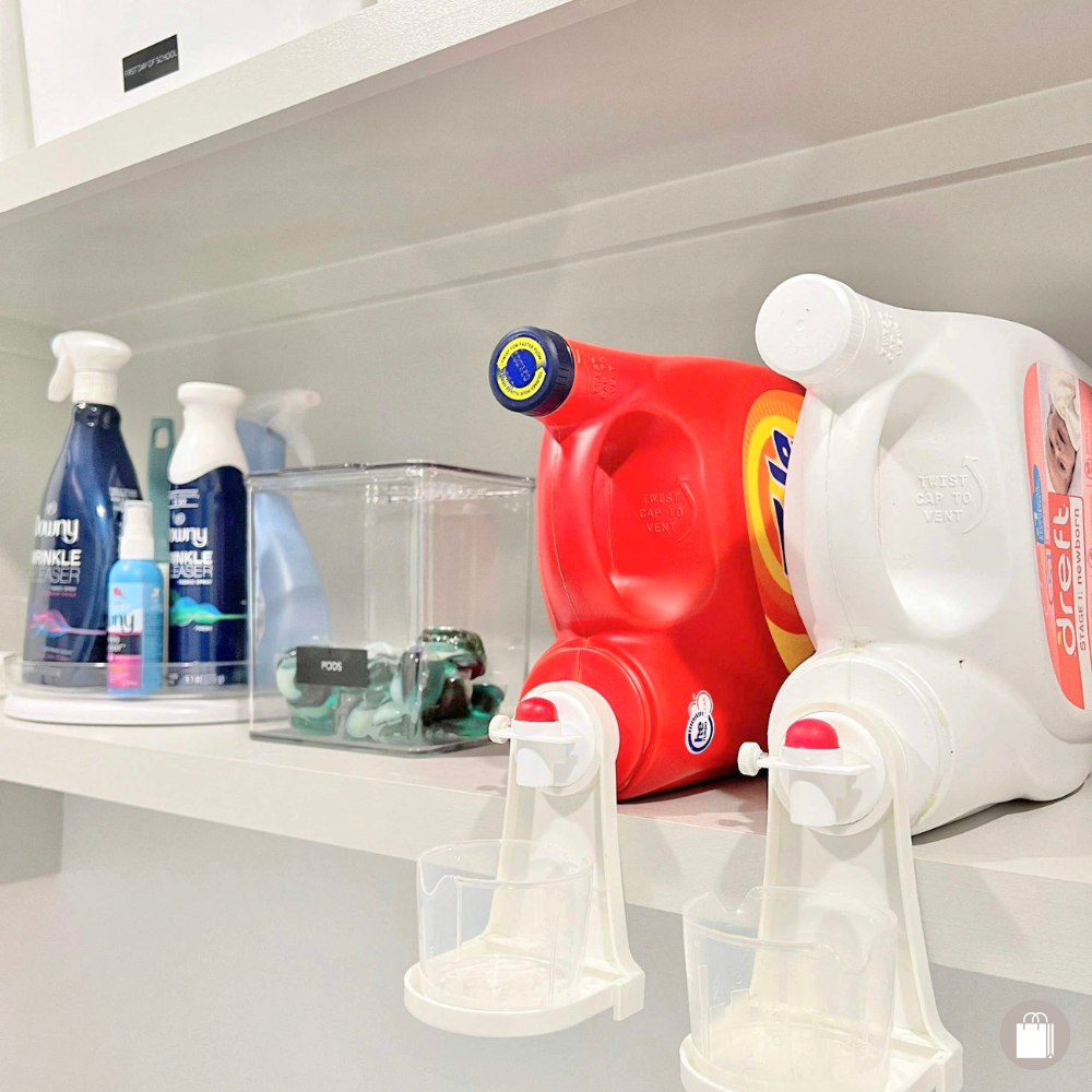 Laundry room shelf with detergent bottles, microfiber towels, a container with small miscellaneous items, and two soap dispensers with cups attached.