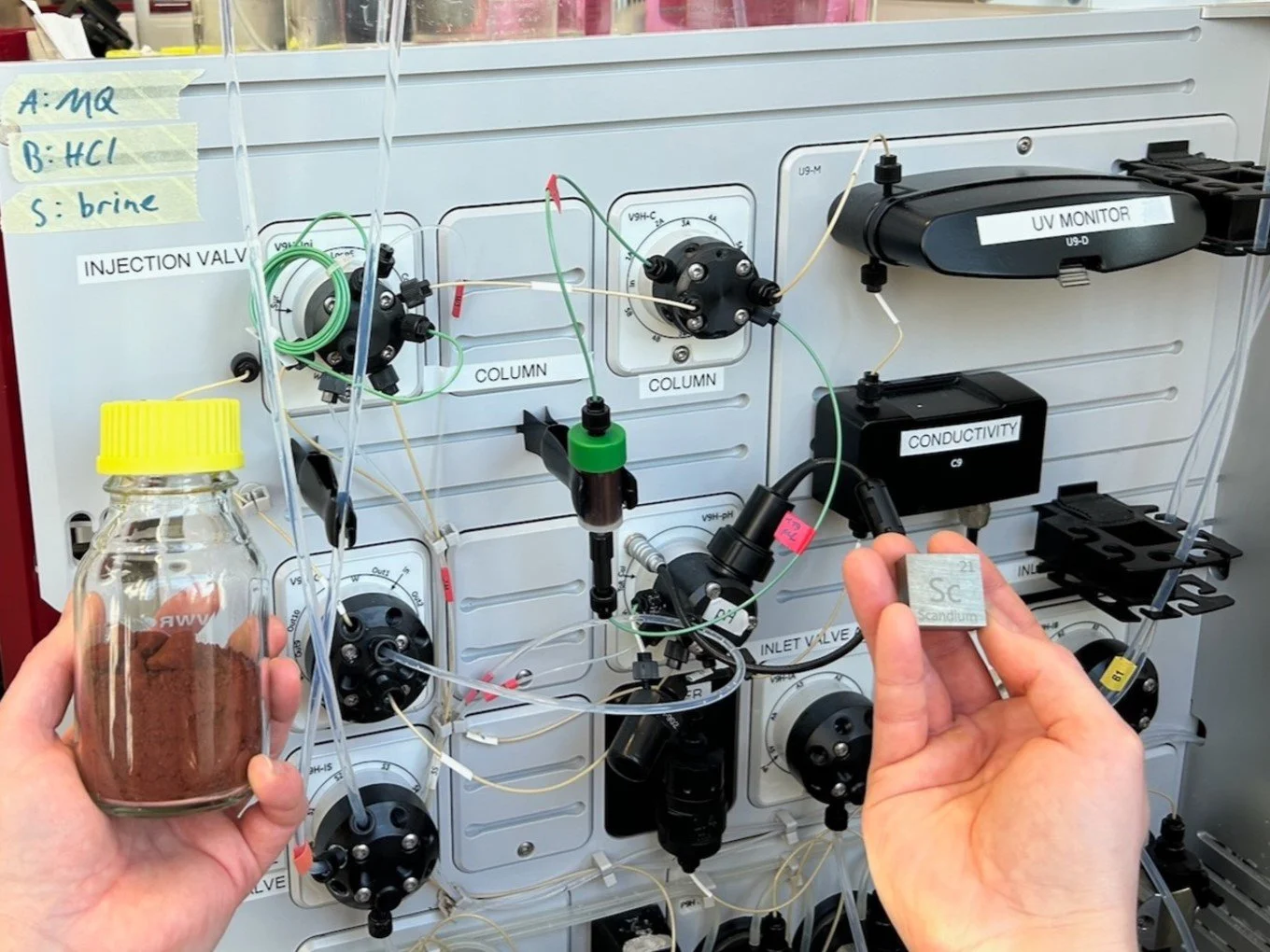 Metal-extraction apparatus, wherein a metal-containing powder is dissolved in solution and run through an extraction column to procure valuable metals (in this case, scandium)