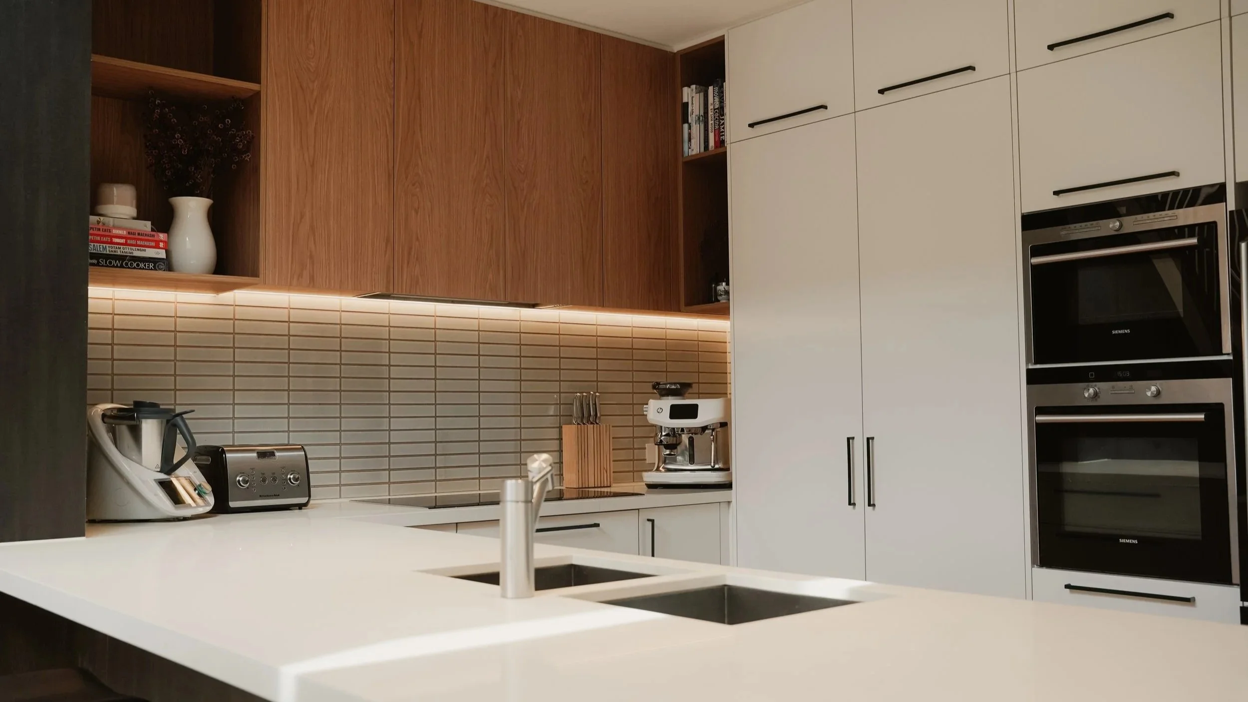 Kitchen cupboards with stone top, two pack painted doors and oak veneer overheads