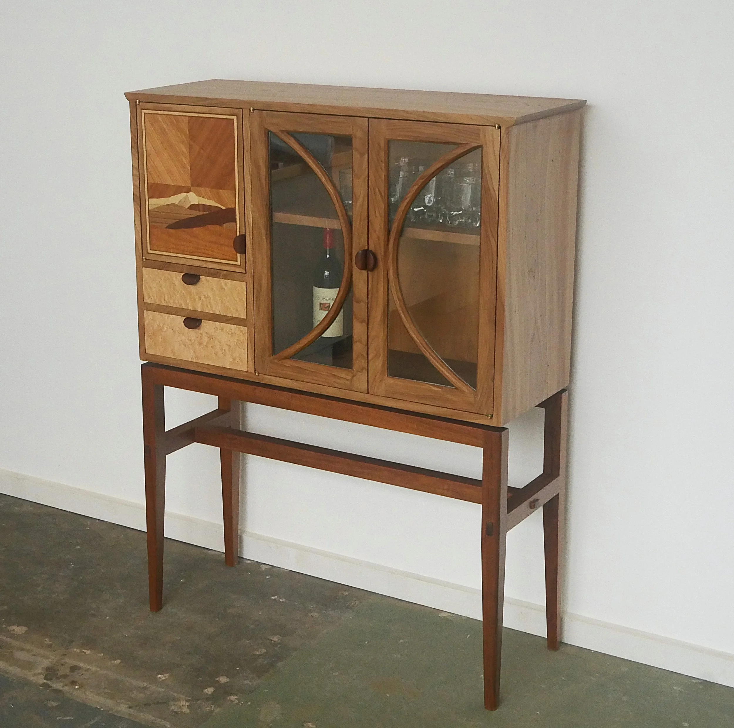 Bespoke whiskey cabinet handmade from elm, blackwood, birdseye maple, gidgee, macrocarpa and liquidambar. featurng intricate joinery and marquetry door.