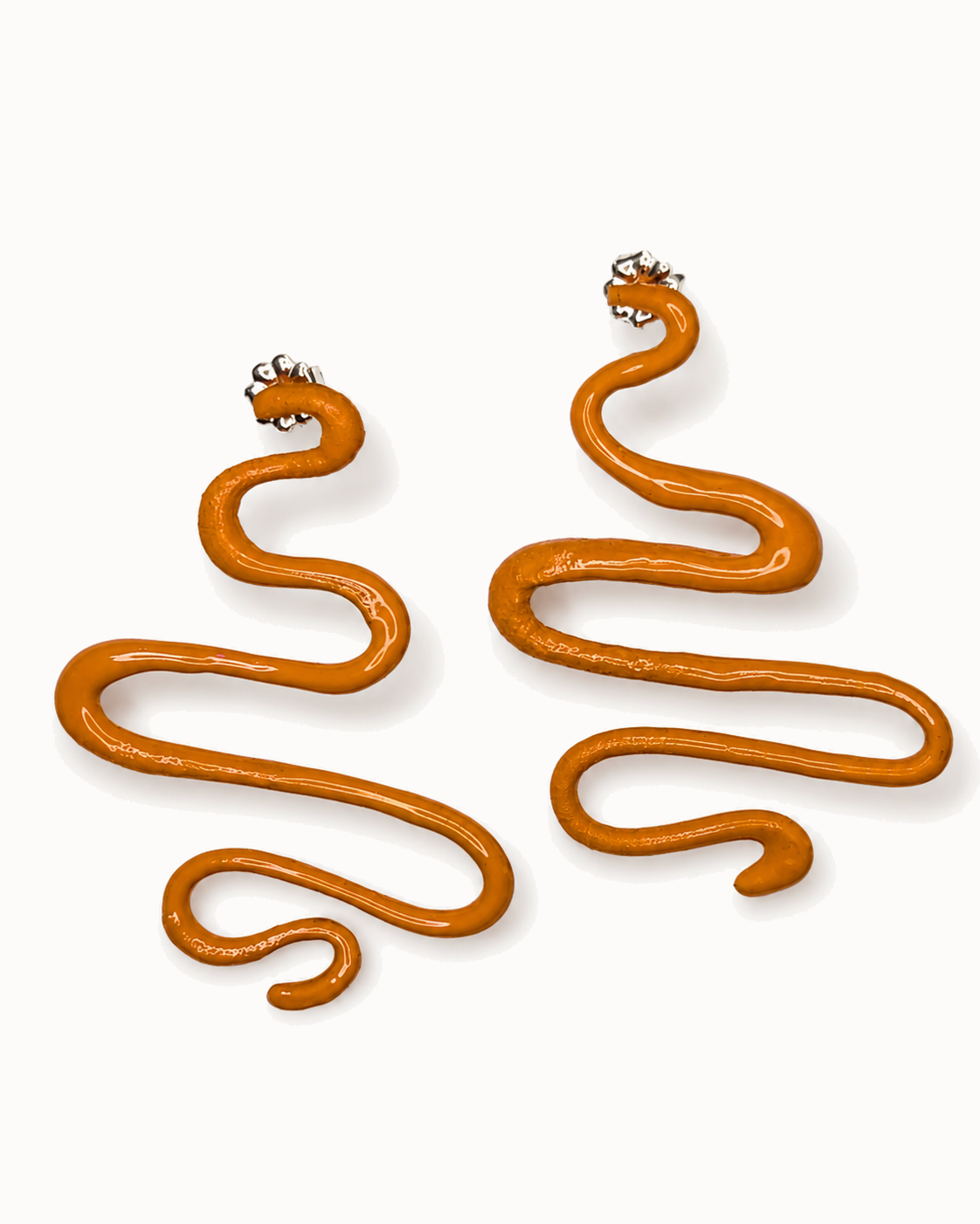 Long sculptural drops in glossy burnt-orange enamel.