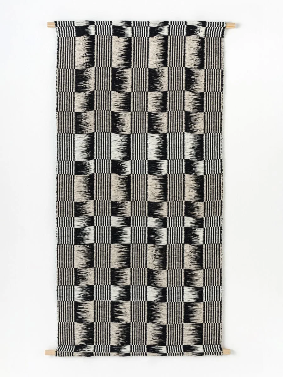 Hanging textile art with black and white geometric checkered pattern