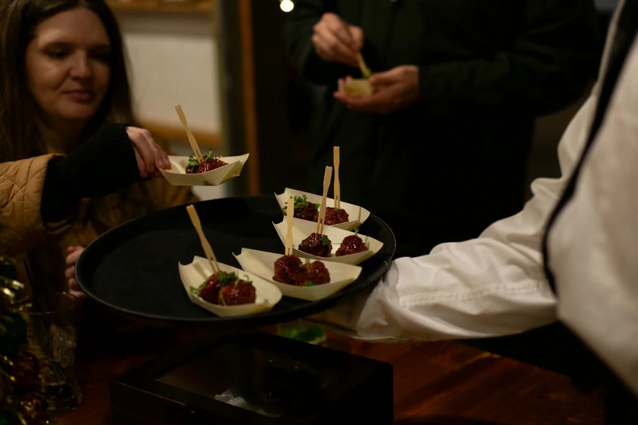 Mama D's staff serving Mama's Cherry Meatballs in passed-appetizer fashion at a private cocktail party.
