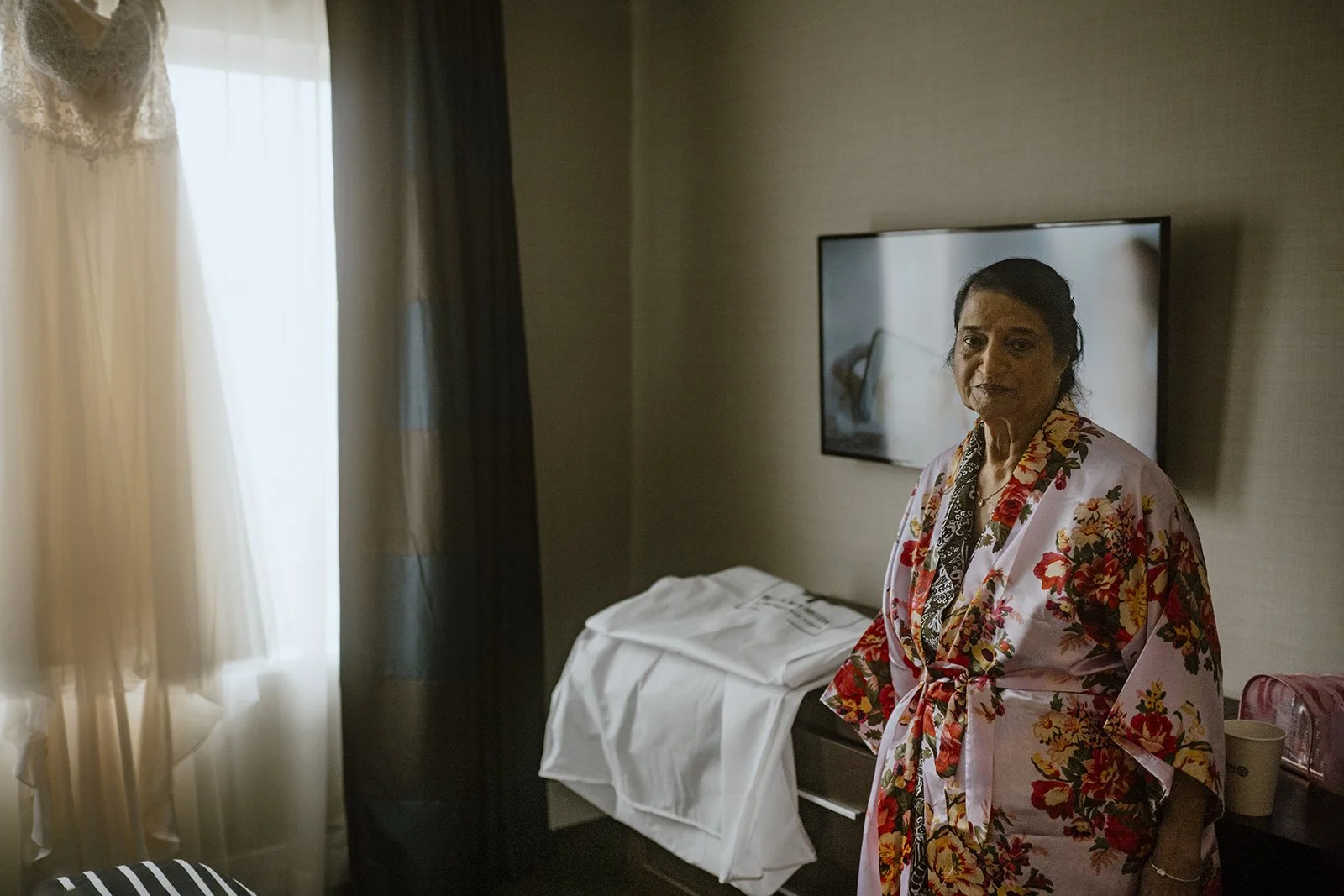 Documentary Wedding photography of Grandma standing with Bride's wedding dress in a toronto hotel