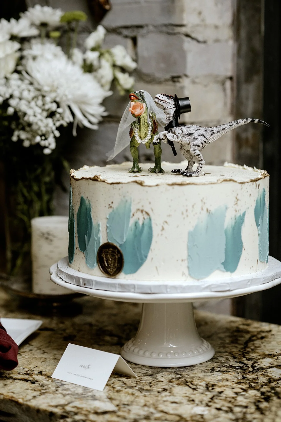 Non-traditional fun wedding cake that has dinosaurs on top at a venue in toronto