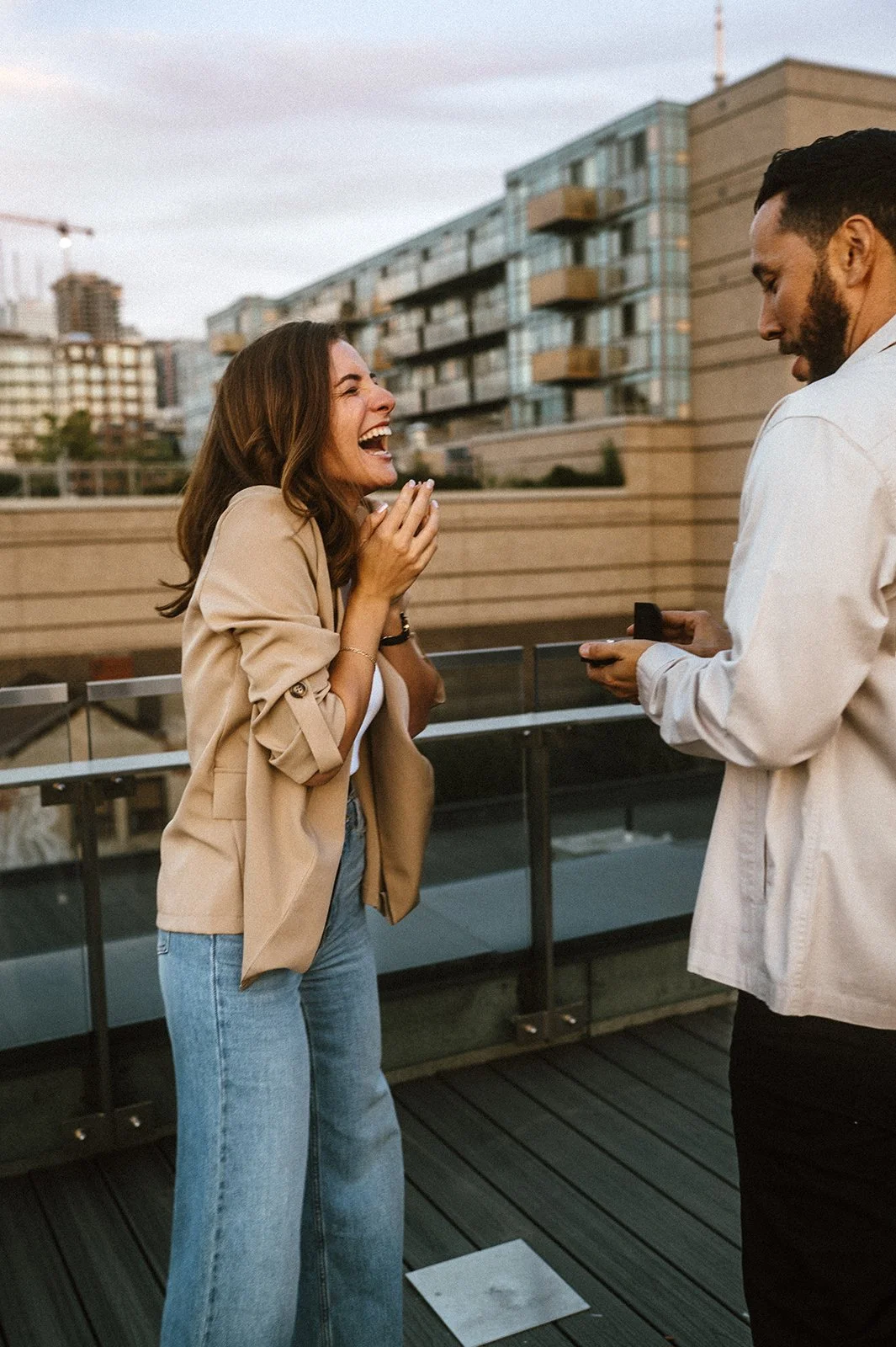 Woman looking happy after surprise proposal on a rooftop in toronto