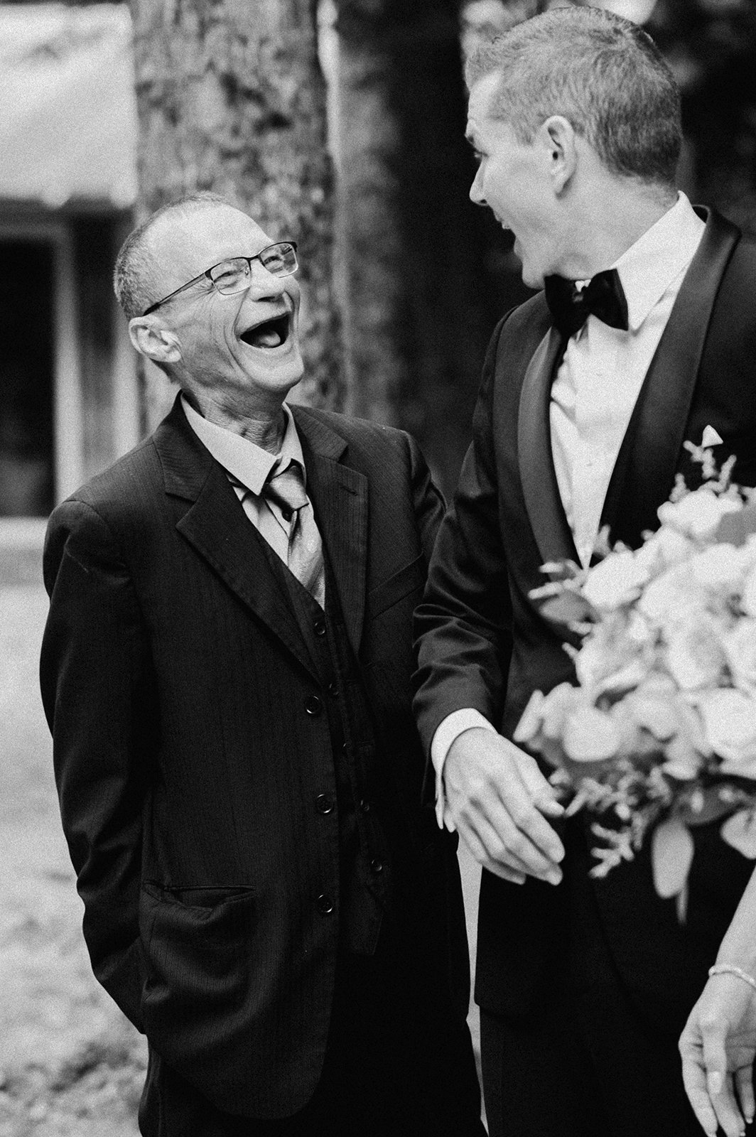 Documentary wedding photography of a dad laughing with the groom