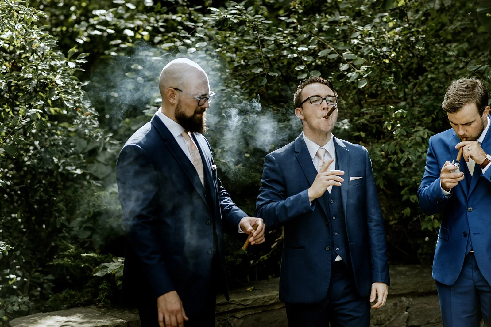 candid photo of groomsmen enjoying cigars during a small outdoor wedding in toronto