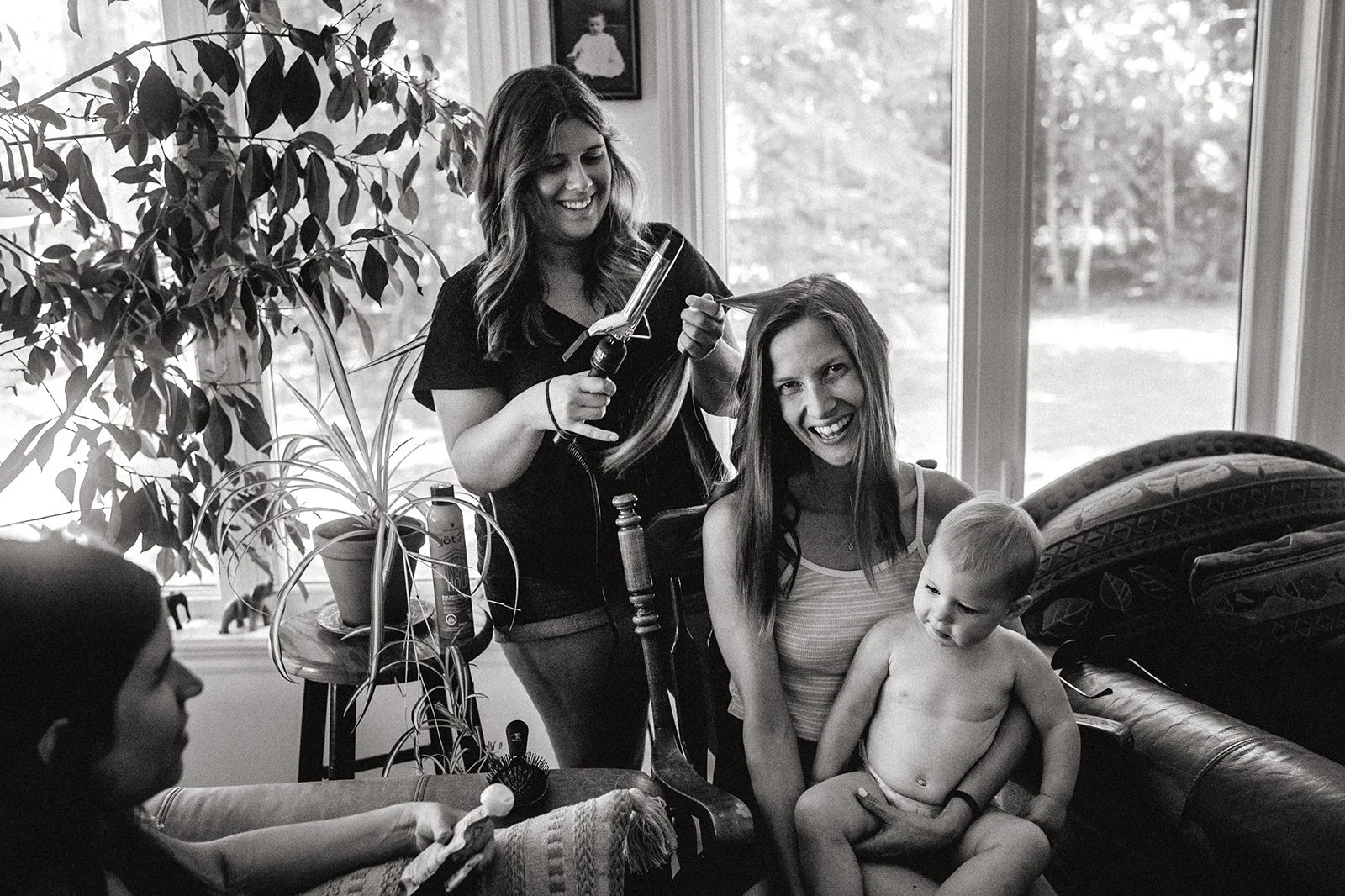 Candid photo of bride getting ready for her small wedding and holding her child