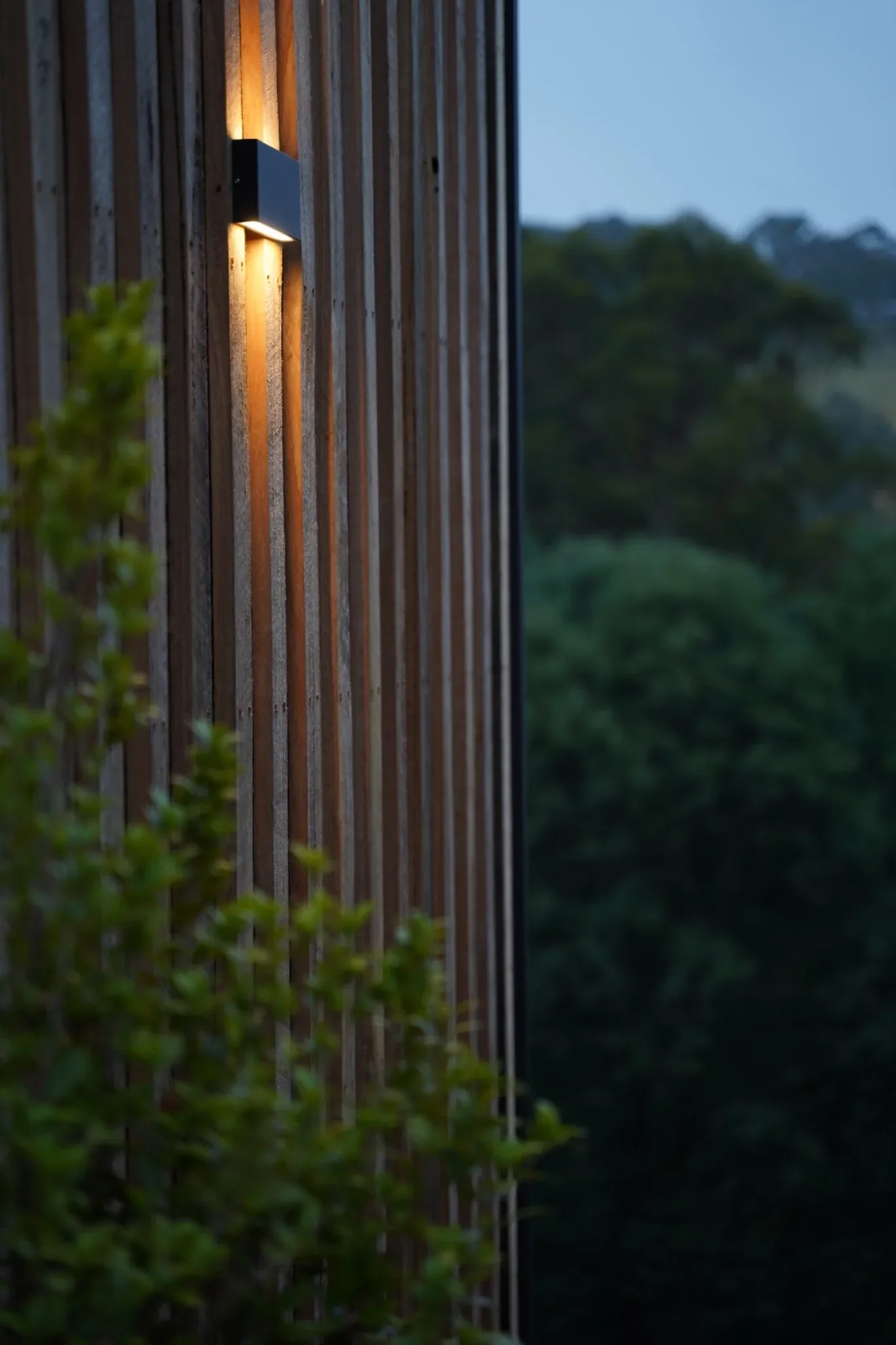 Exterior wall light on vertical timber cladding of a modern modular home in Victoria