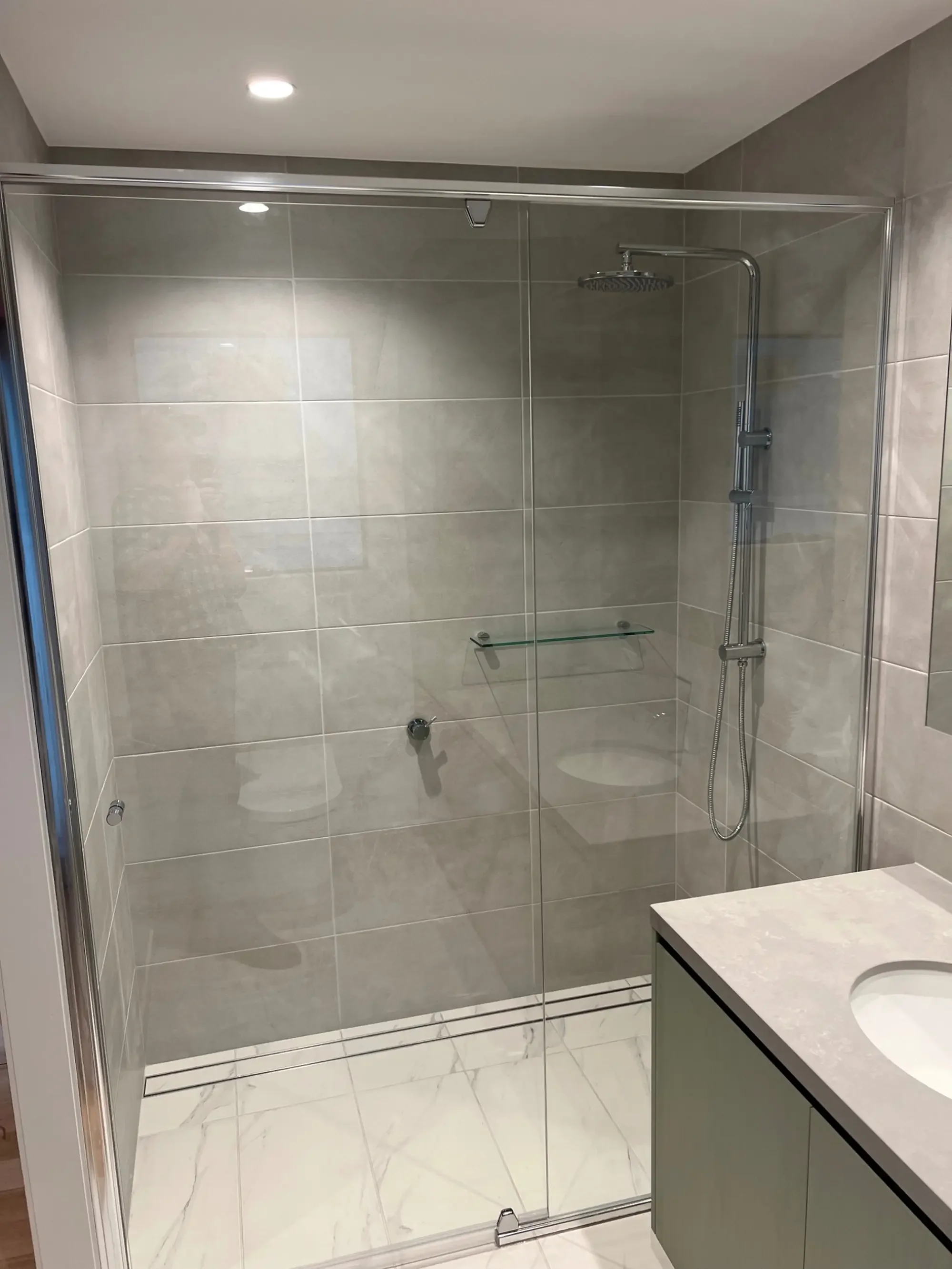 Modern modular home bathroom with walk-in shower and tiled interior in Victoria