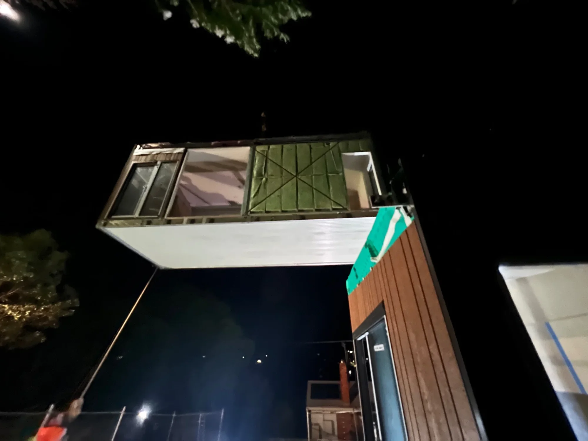 Modular home being installed by crane at night in Australia