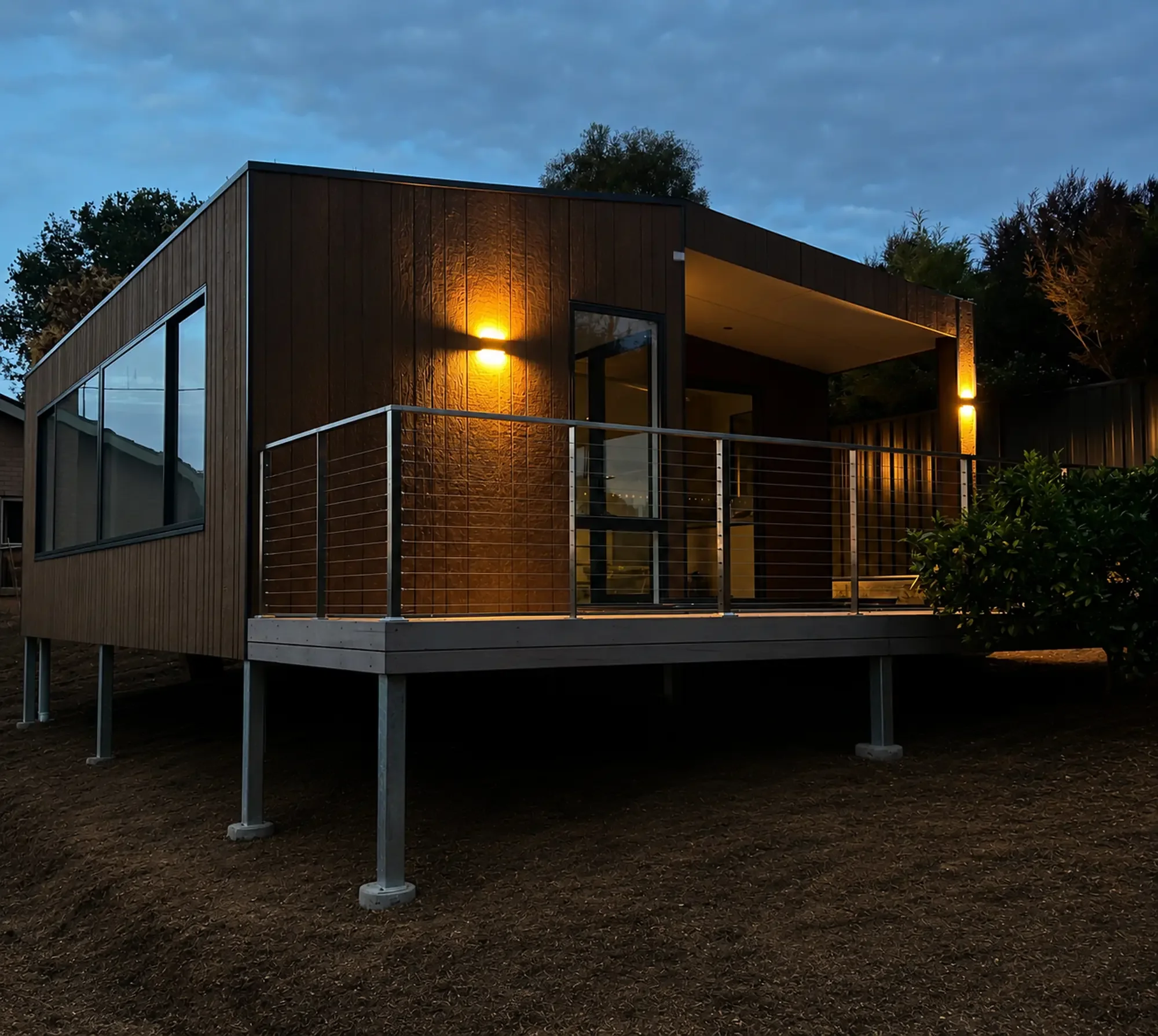Modern modular home exterior with covered deck at twilight in Victoria