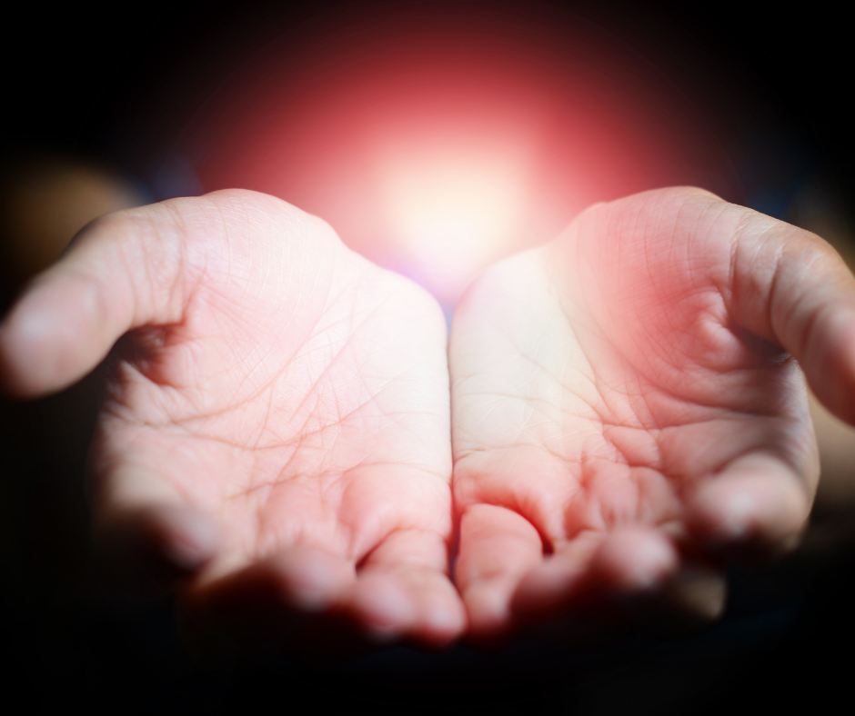 Cupped hands holding a soft red glow, representing the ACT principle of willingness and acceptance of difficult emotions during insomnia.