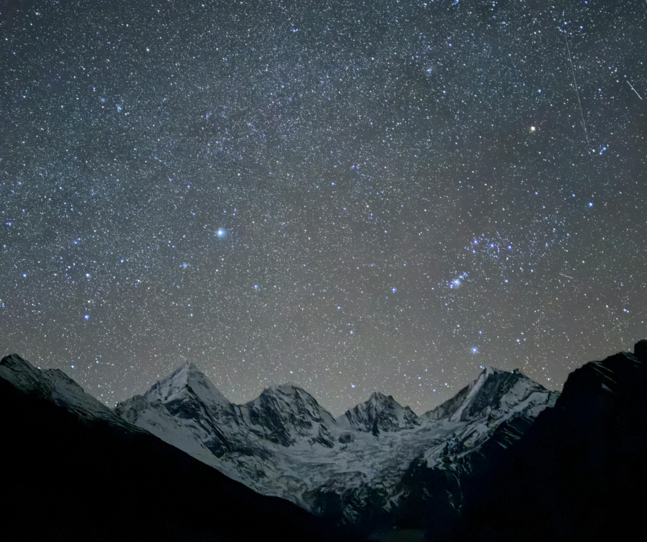 A vast, starry night sky over a silhouette of snow-capped mountains, representing a shift in perspective toward wakefulness in ACT-I.