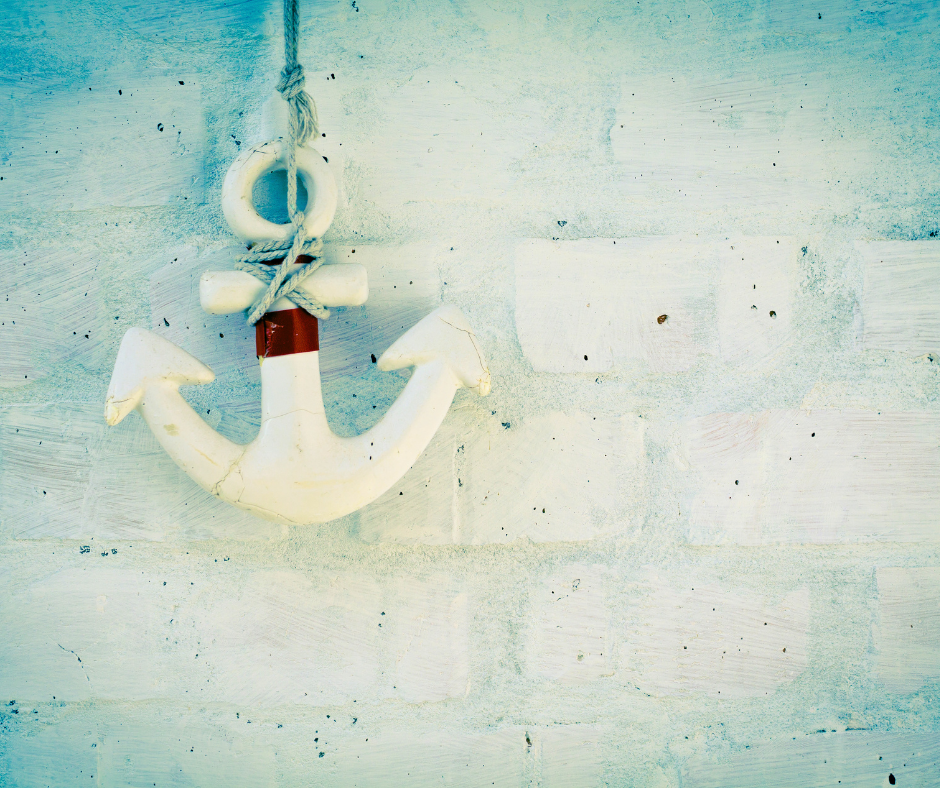 A white nautical anchor hanging against a white-washed brick wall, representing the ACT-I grounding exercise for insomnia.
