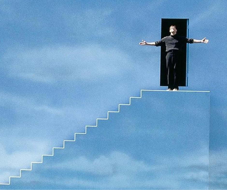 Truman Burbank from The Truman Show standing at a dark doorway built into a blue-sky wall, representing the courageous transition from a trauma-based identity to an authentic life.