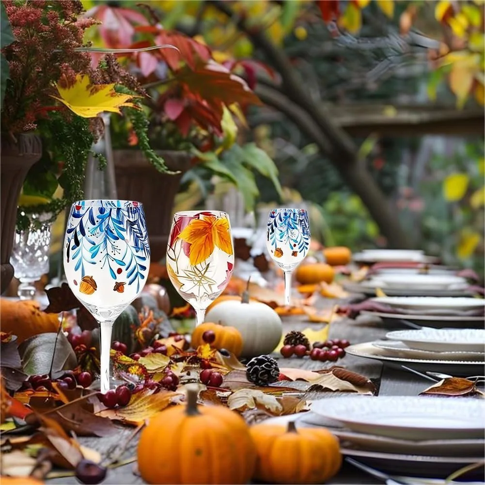 Autumn outdoor table setting with fall leaves, pumpkins, berries, and decorative blue and yellow glasses.