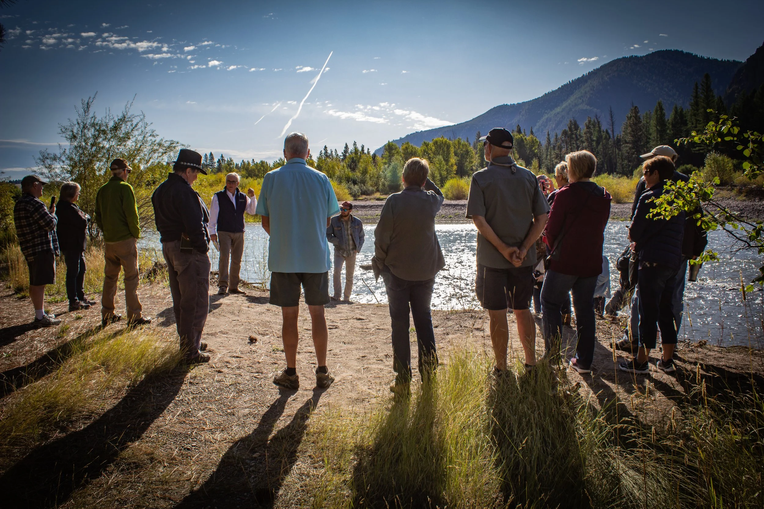 people standing along a riverbank