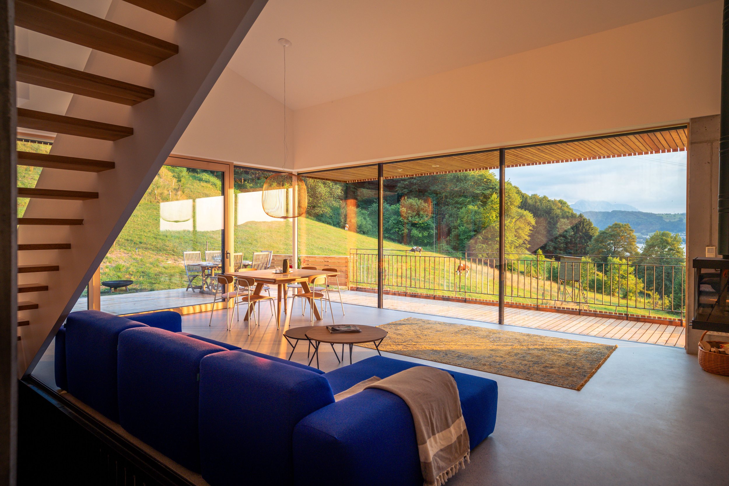 Floor-to-ceiling glass elements create a seamless connection between inside and out, bringing nature directly into the living room.