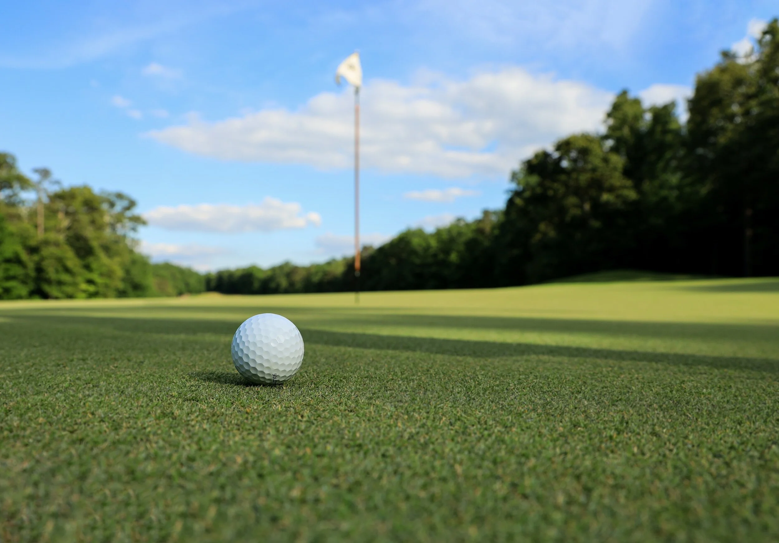 Golf ball on a green facing the flag